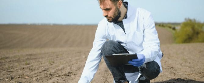 Dynamic compaction crane operating on a large construction site with visible soil impact zones, demonstrating ground preparation for load-bearing enhancement.