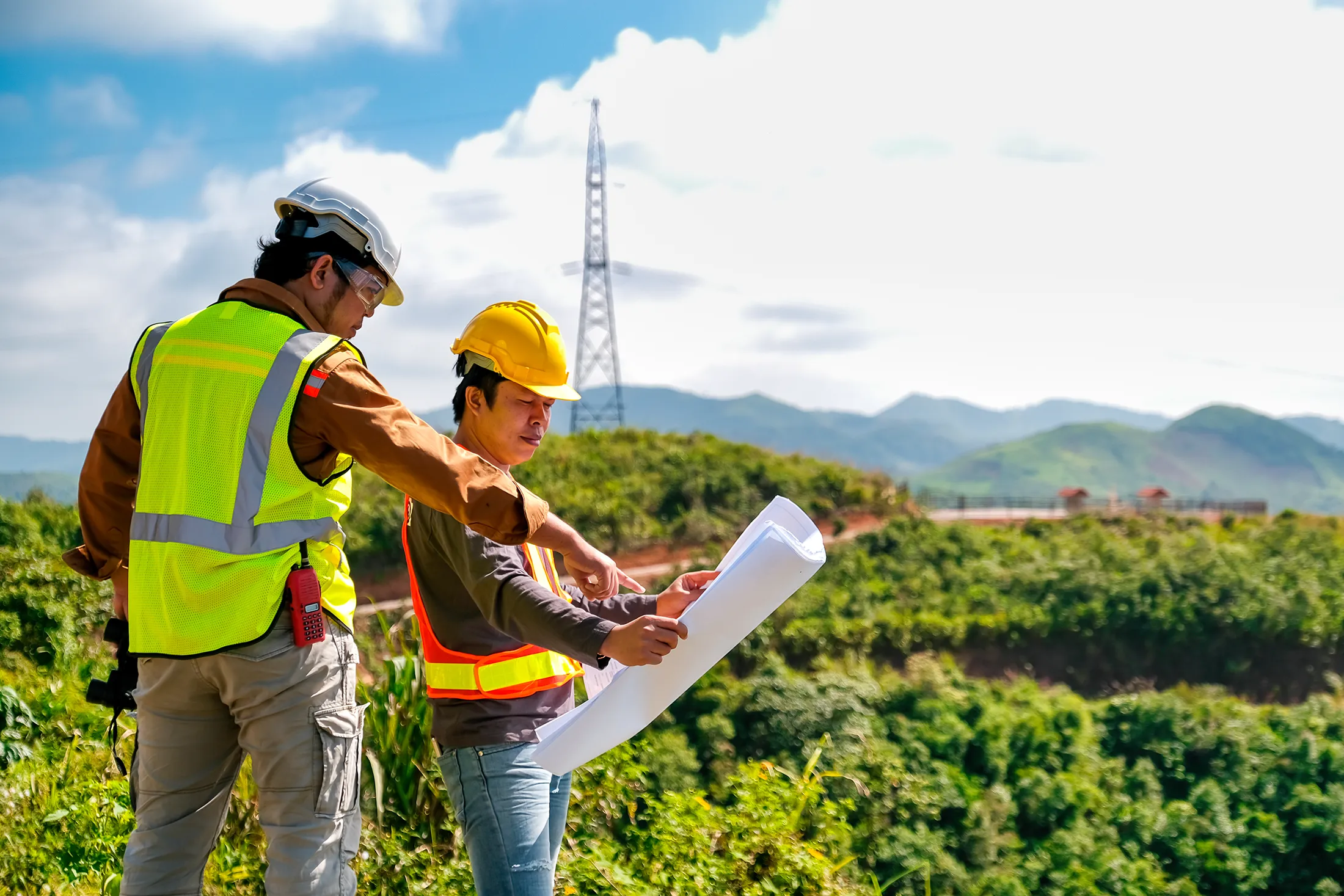 Engineer head point to the planer paper and discuss with his team for the construction near the forest with copy space in image.
