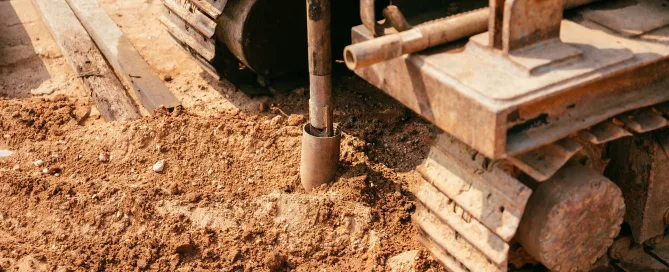 Close-up of heavy construction equipment drilling into soil for ground improvement.