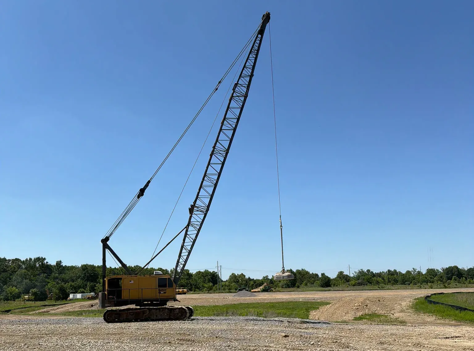 crawler-crane-on-stone-pad-madisonville-kentucky-densification. Yellow American crawler crane with a raised tamper on a crushed stone pad in Madisonville, Kentucky