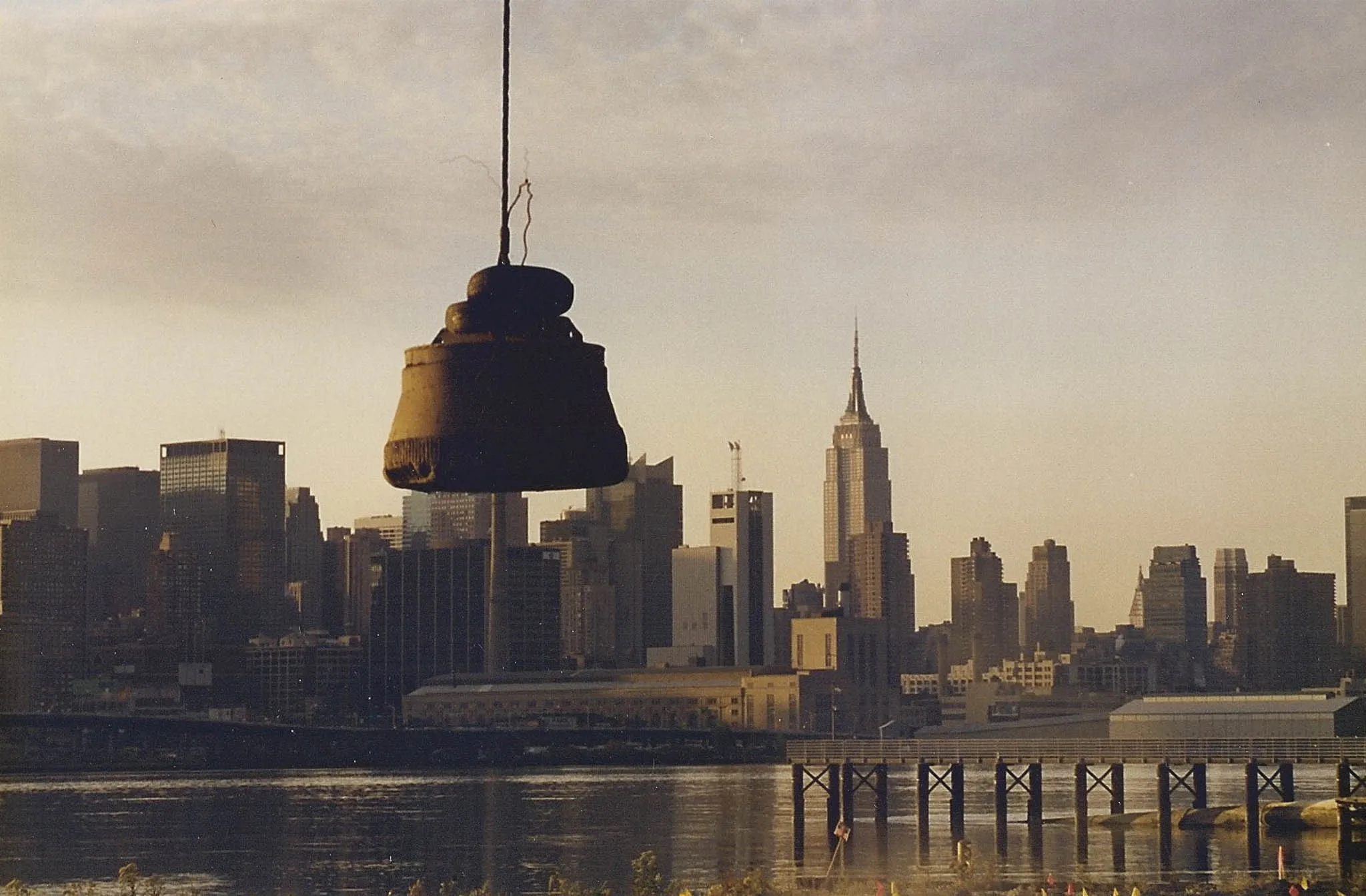 tamper-over-manhattan-skyline-west-new-york-densification. Compaction tamper suspended above the Hudson River with the Manhattan skyline and Empire State Building behind